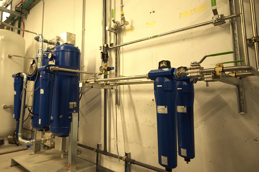Compressed-air dryers and filters beside storage receivers